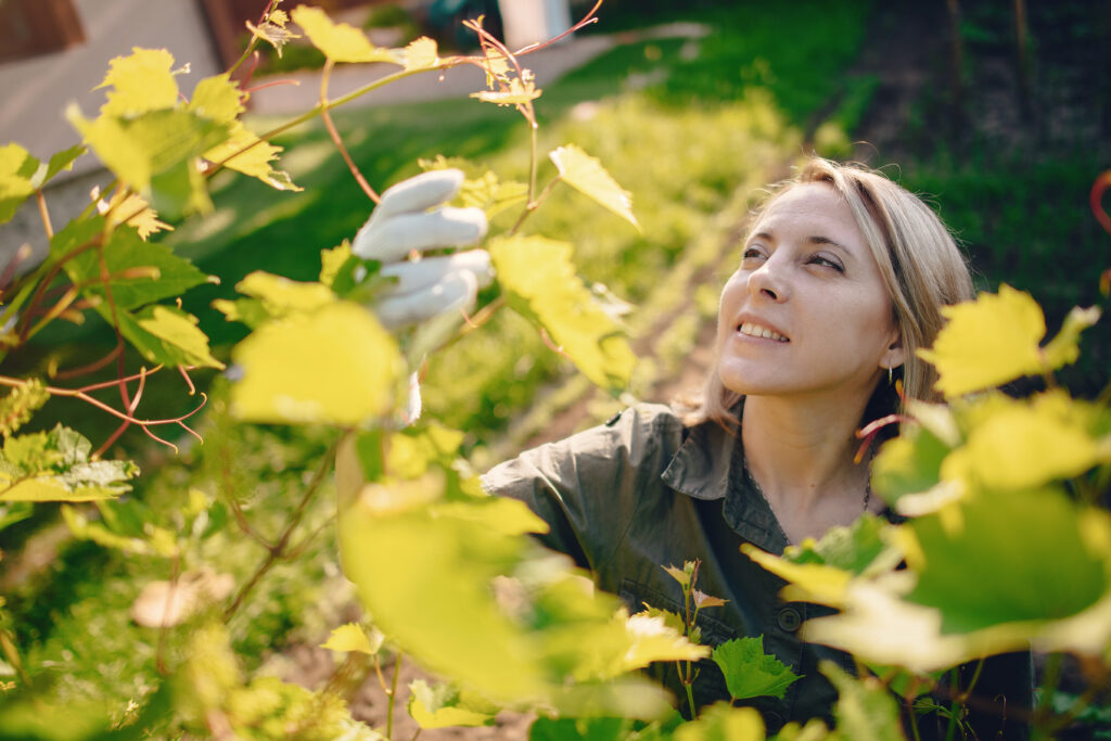 Beautiful woman works in a garden near the house
